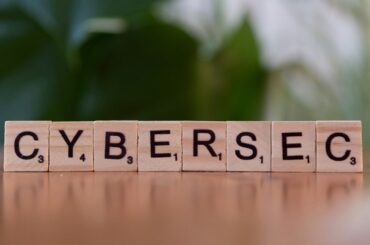A wooden block spelling cybersec on a table