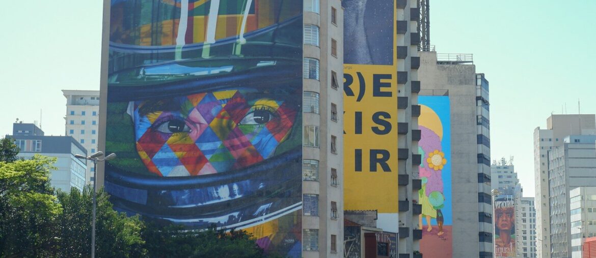Colorful murals decorate a high-rise building.