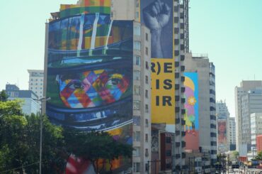 Colorful murals decorate a high-rise building.