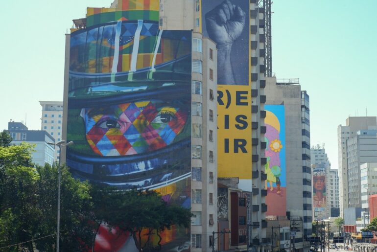 Colorful murals decorate a high-rise building.